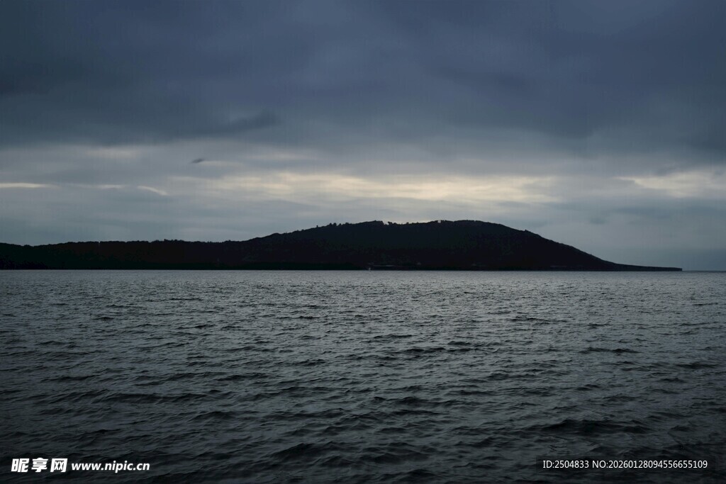 海上乌云笼罩的静谧岛屿