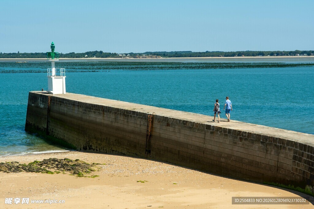 海边长堤上的悠闲身影