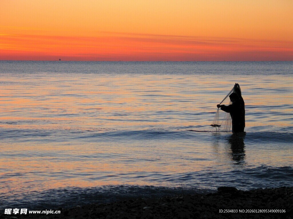 夕阳下的海边垂钓者