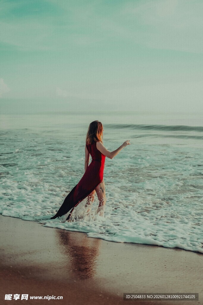 红衣女子海边踏浪起舞