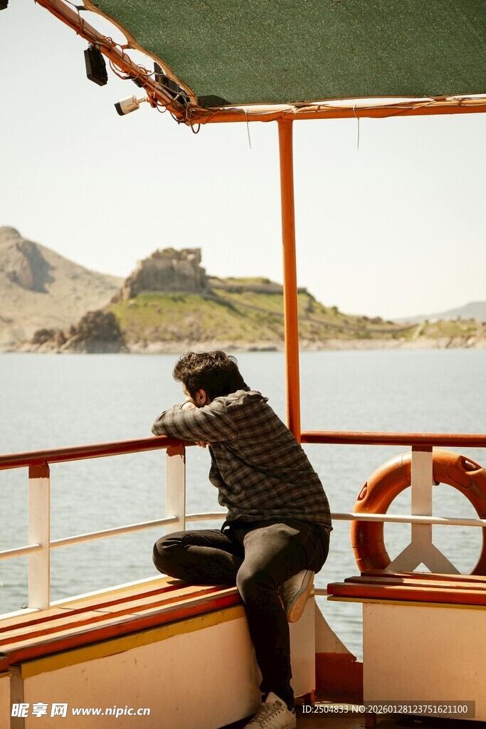 船上男子专注拍摄风景