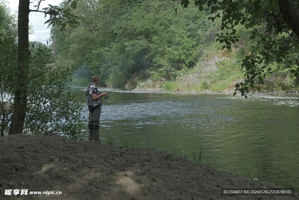 河边单人专注垂钓画面