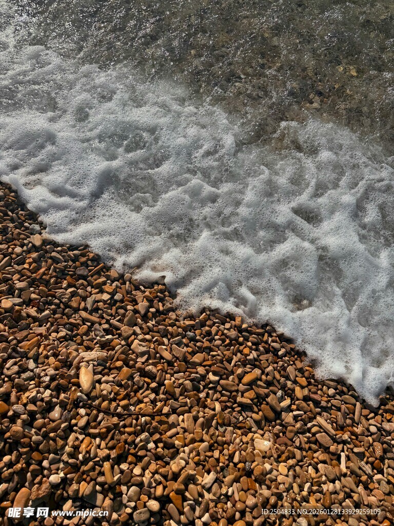 海浪拍打布满石子的沙滩
