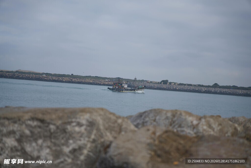 海边岩石与远处船只景象
