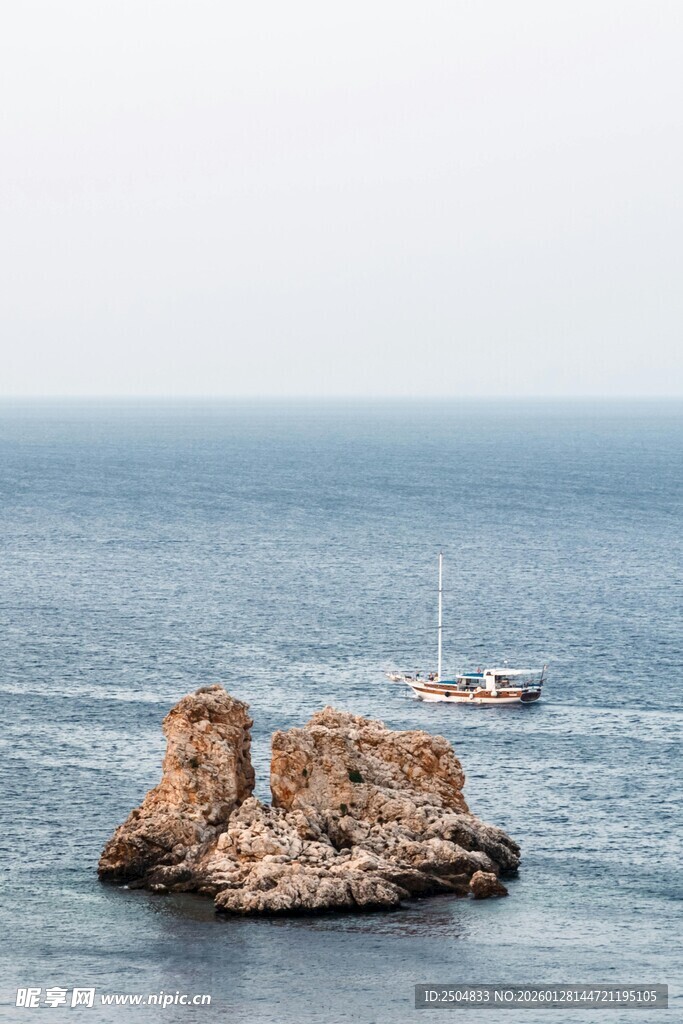 海上孤石旁的航行船只