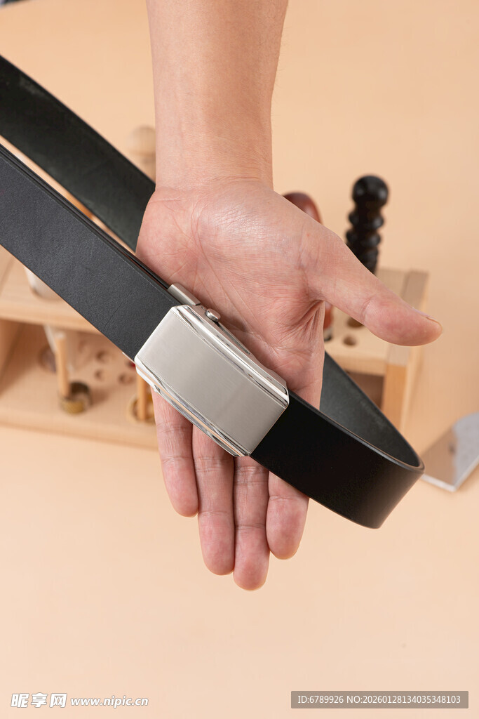 手持黑色皮带金属扣特写