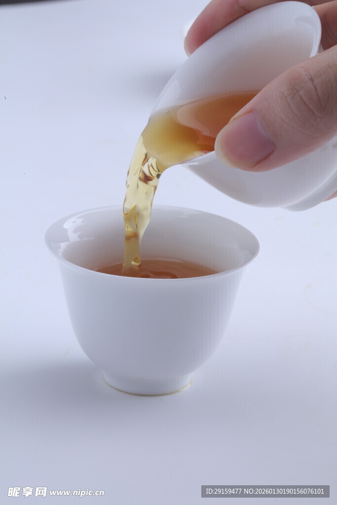手倾壶倒茶入白瓷杯