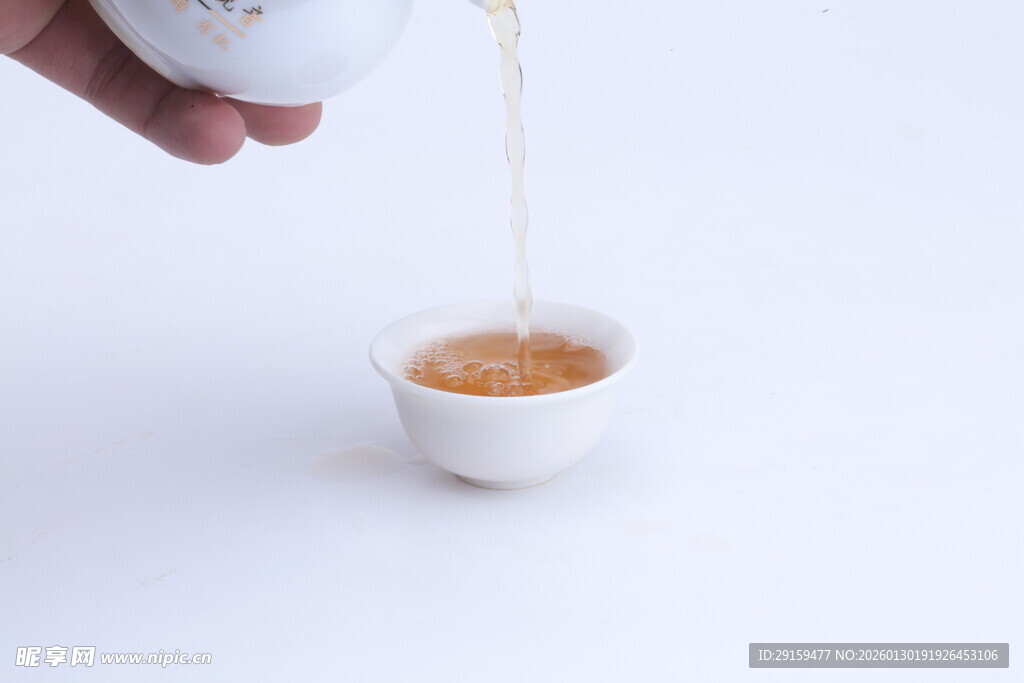 手倾茶壶注茶入白瓷杯