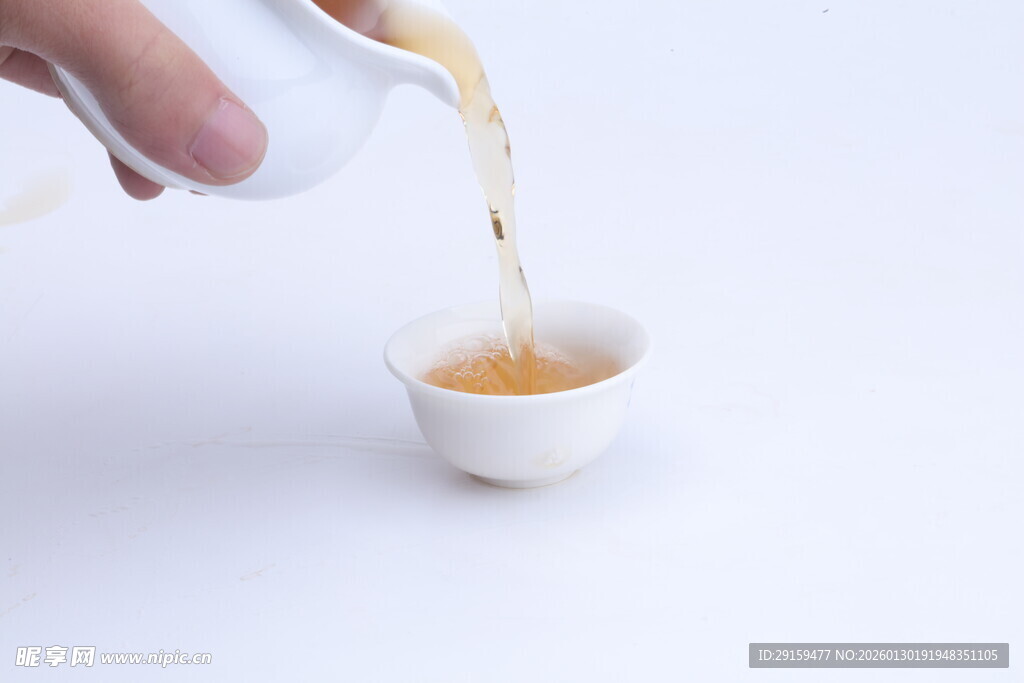 手倾茶壶倒茶入白瓷杯