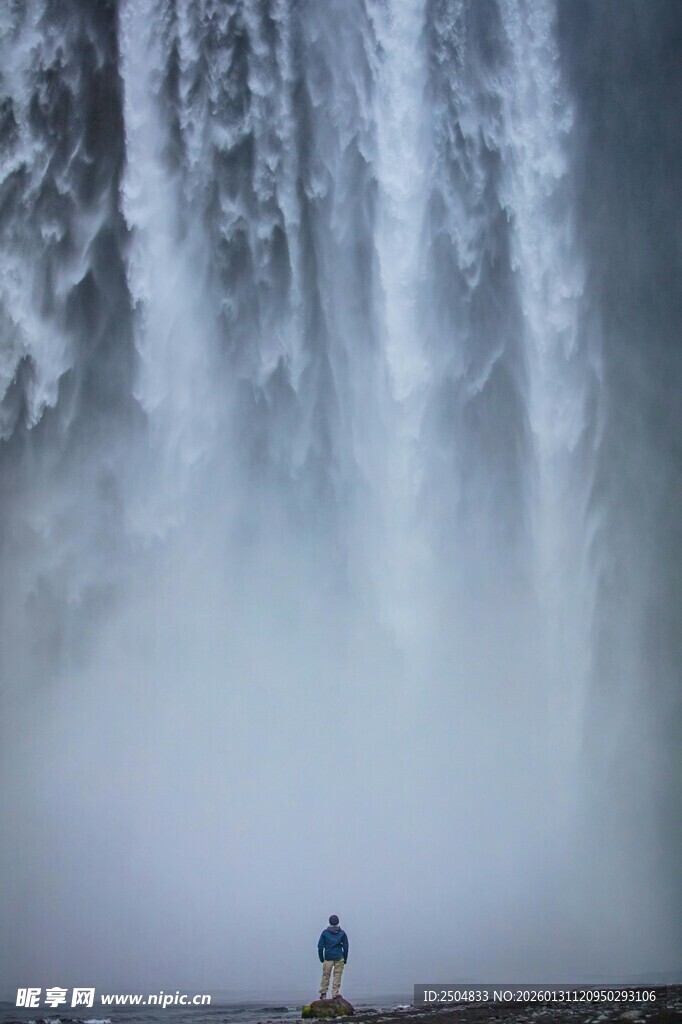 人立于磅礴瀑布前景象