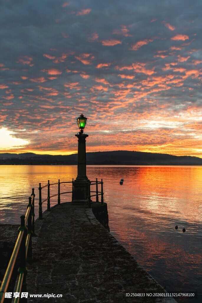 日落时分的灯塔与宁静湖面