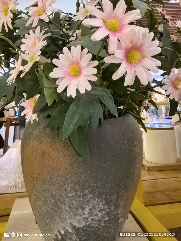 石盆中的粉色雏菊花束