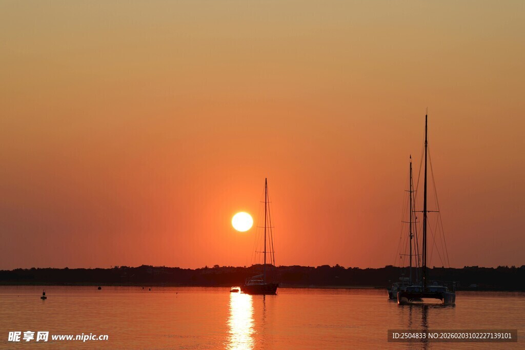 夕阳下的海面与帆船