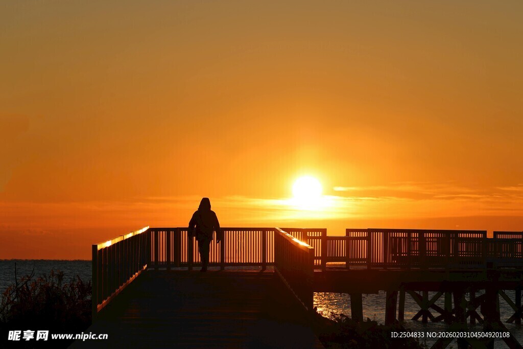 夕阳下栈桥的孤独身影