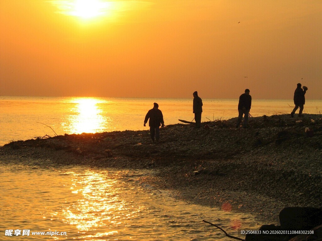 夕阳下海边的几个人影