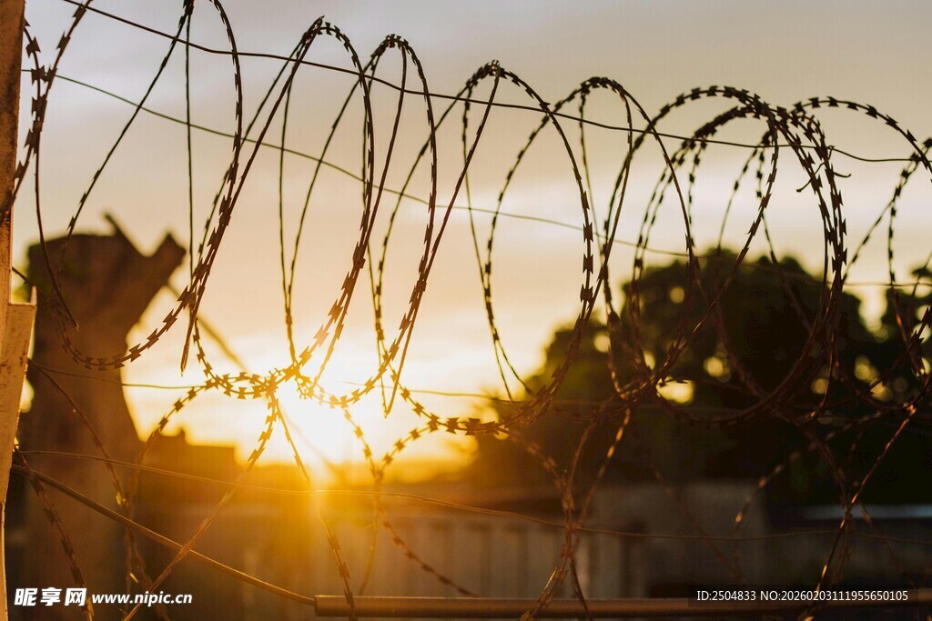 夕阳下的带刺铁丝网