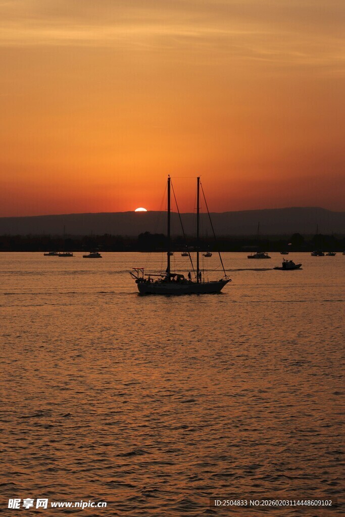 海上落日下的帆船美景