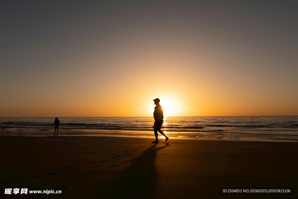 夕阳下海滩上的孤独身影