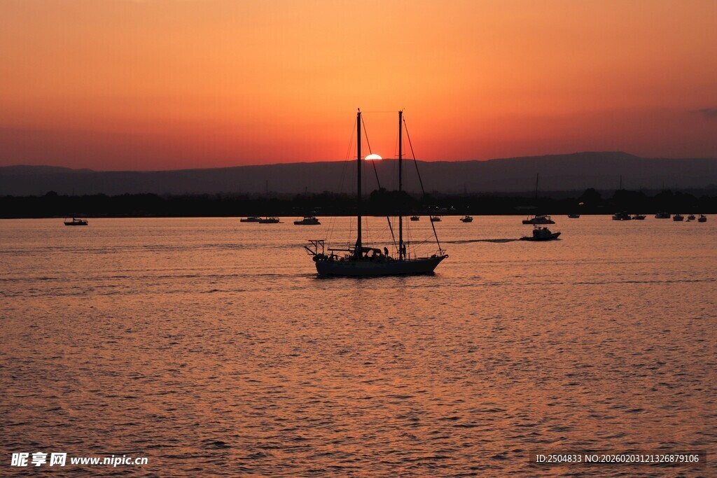 夕阳下的海面与帆船