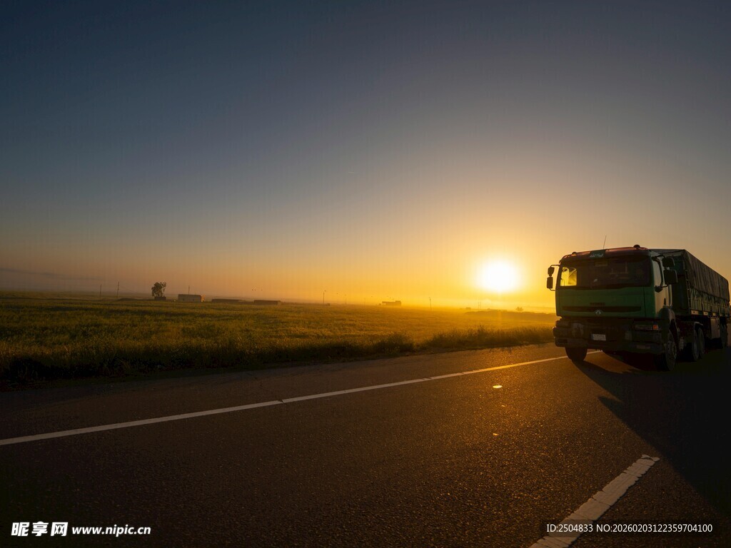 公路上的夕阳下行驶货车