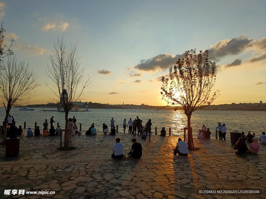 夕阳下沙滩上的休闲人群