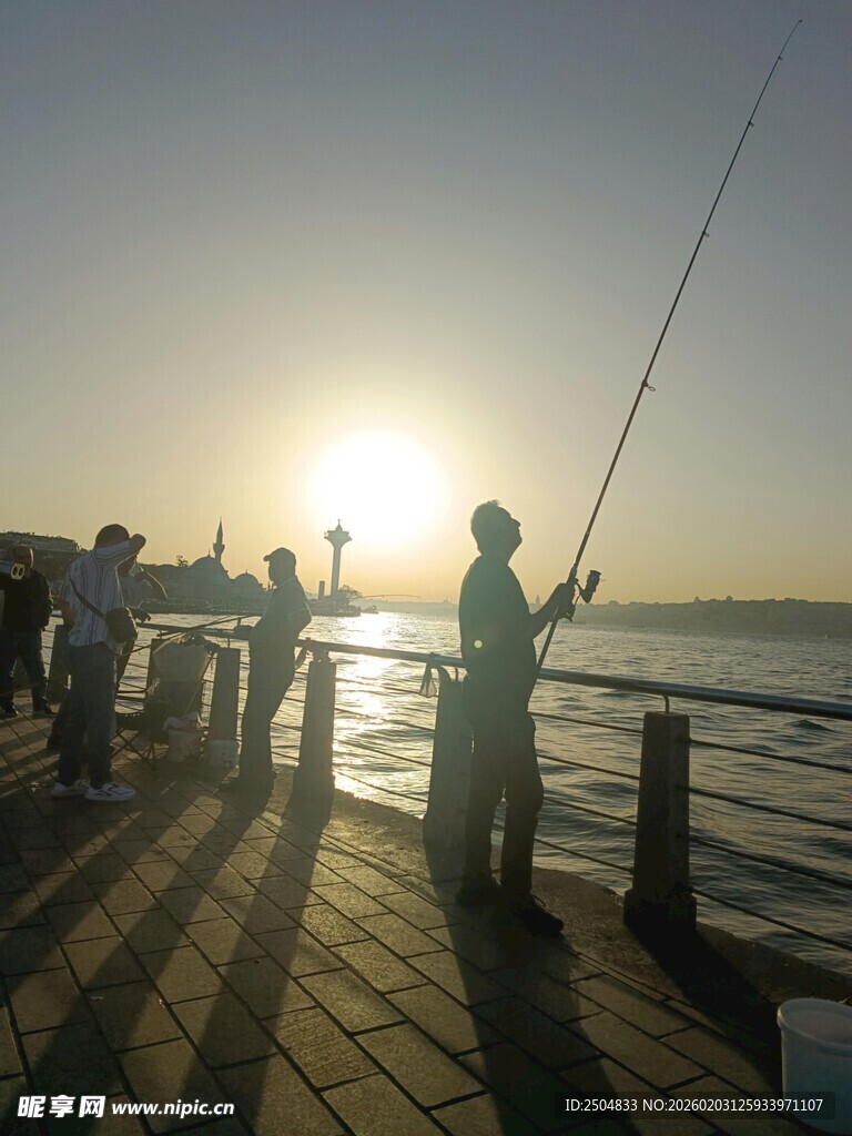 夕阳下的海边垂钓者