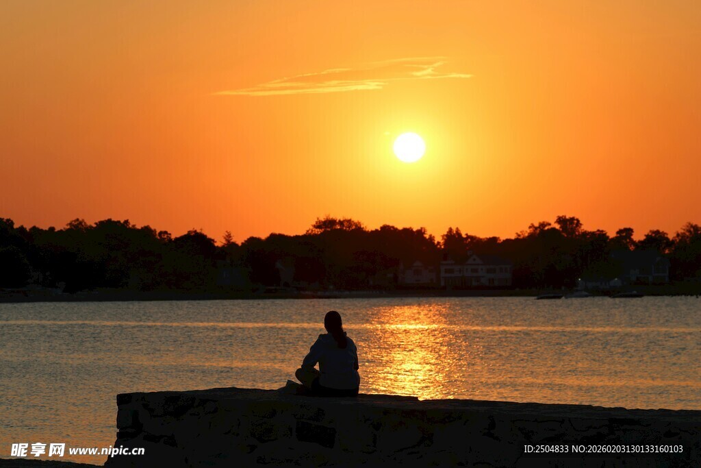 夕阳下独坐水边的身影