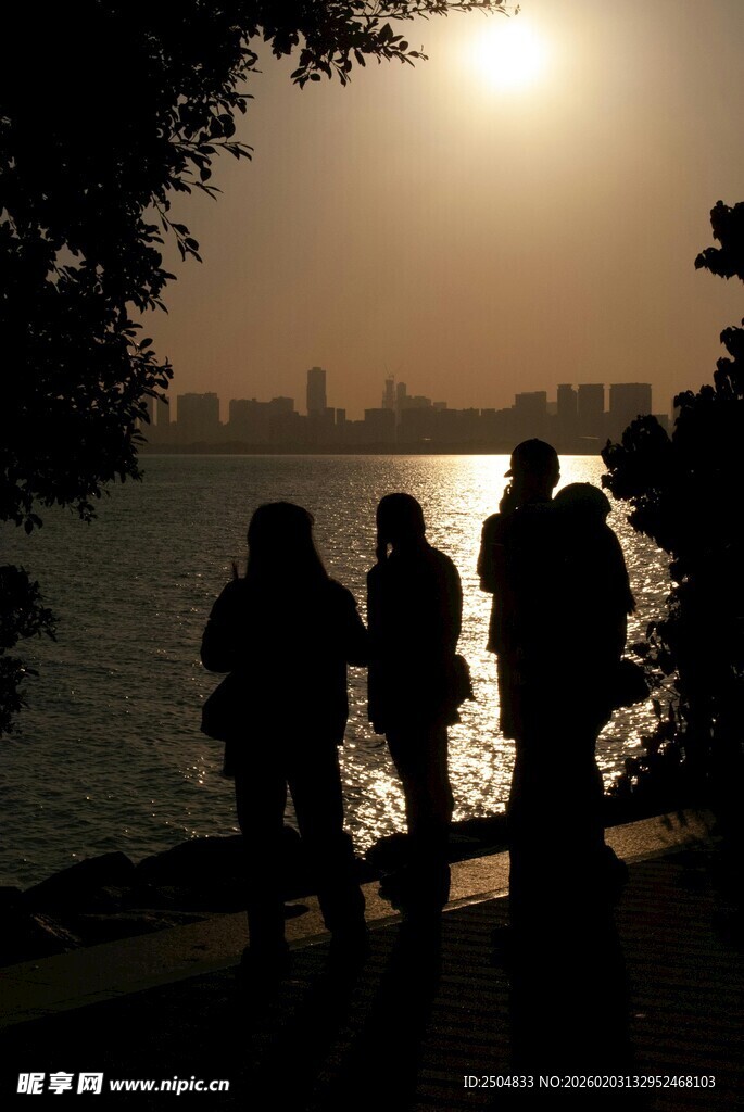 夕阳下的四人岸边剪影