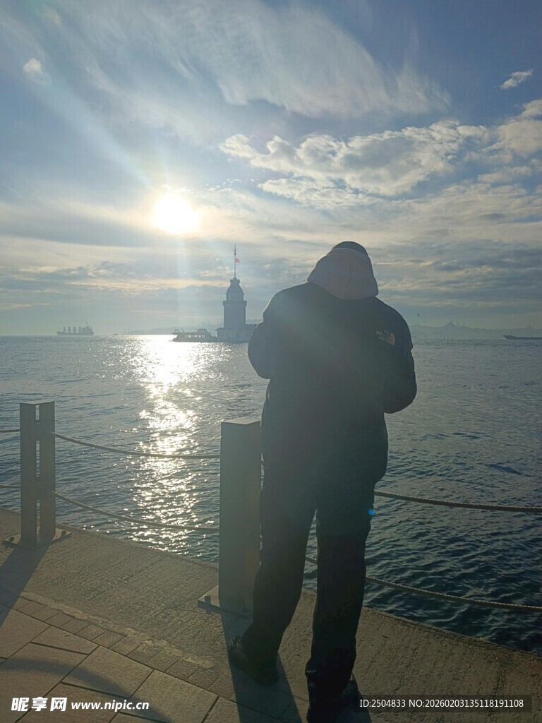 海边男子逆光而立赏景