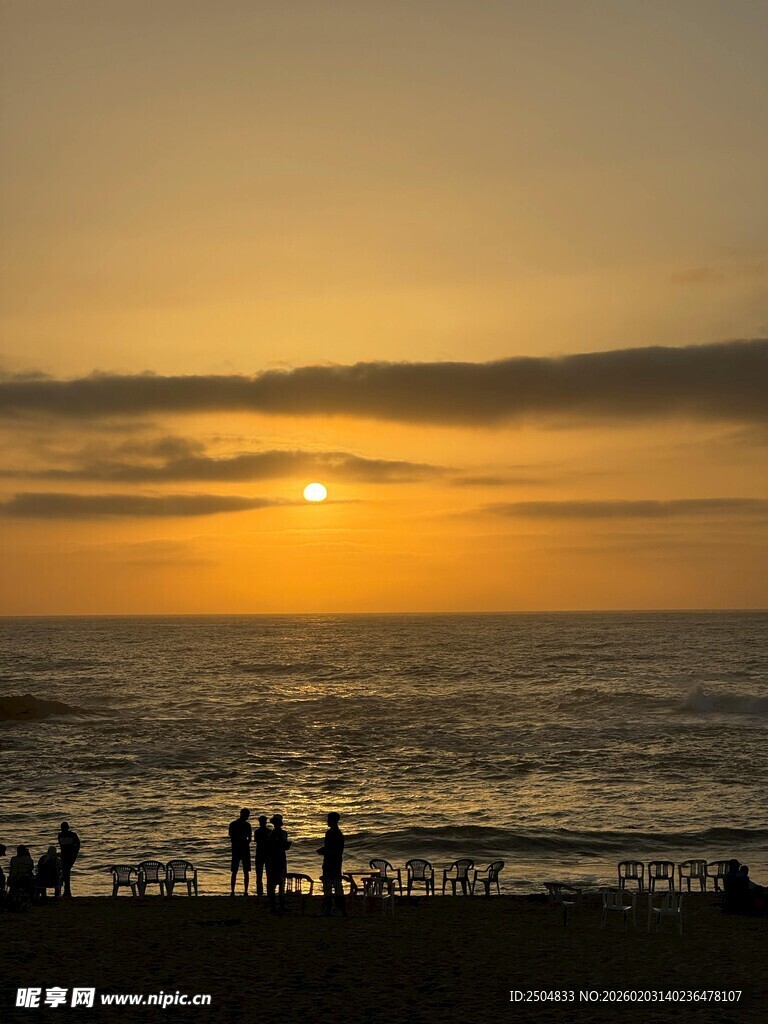 海边日落时的悠闲人群