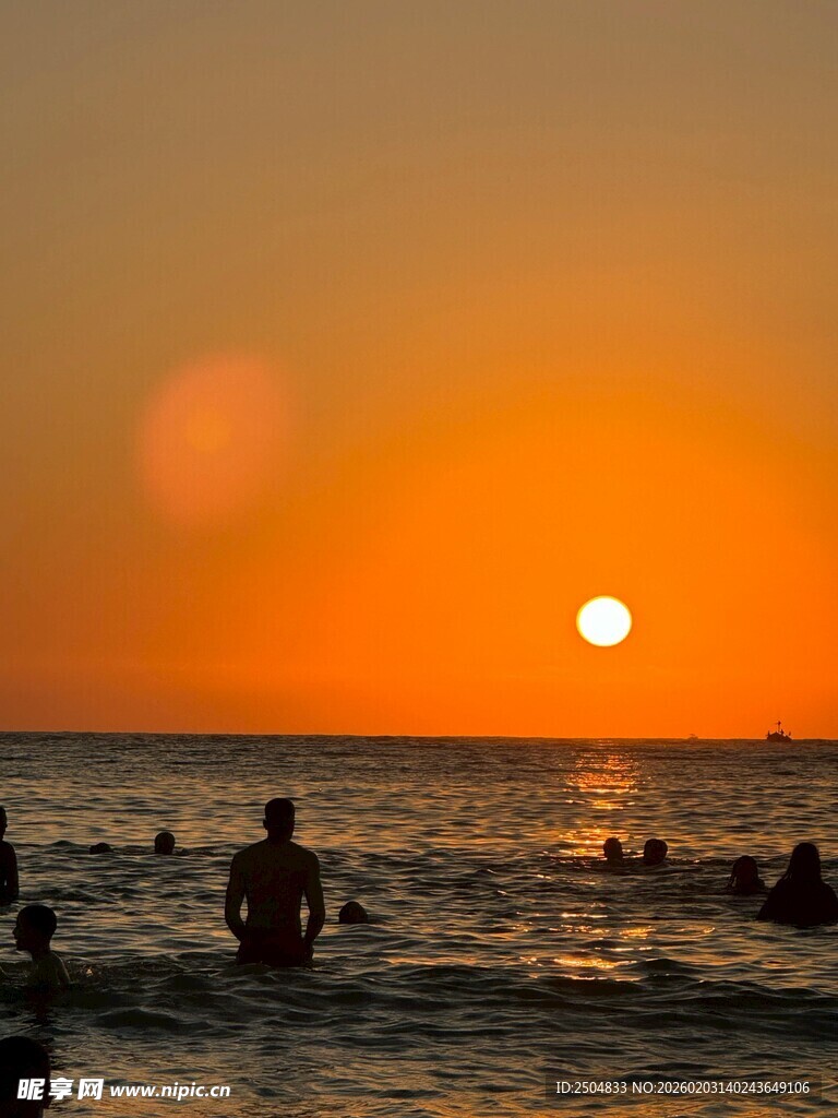 夕阳下的海边戏水场景