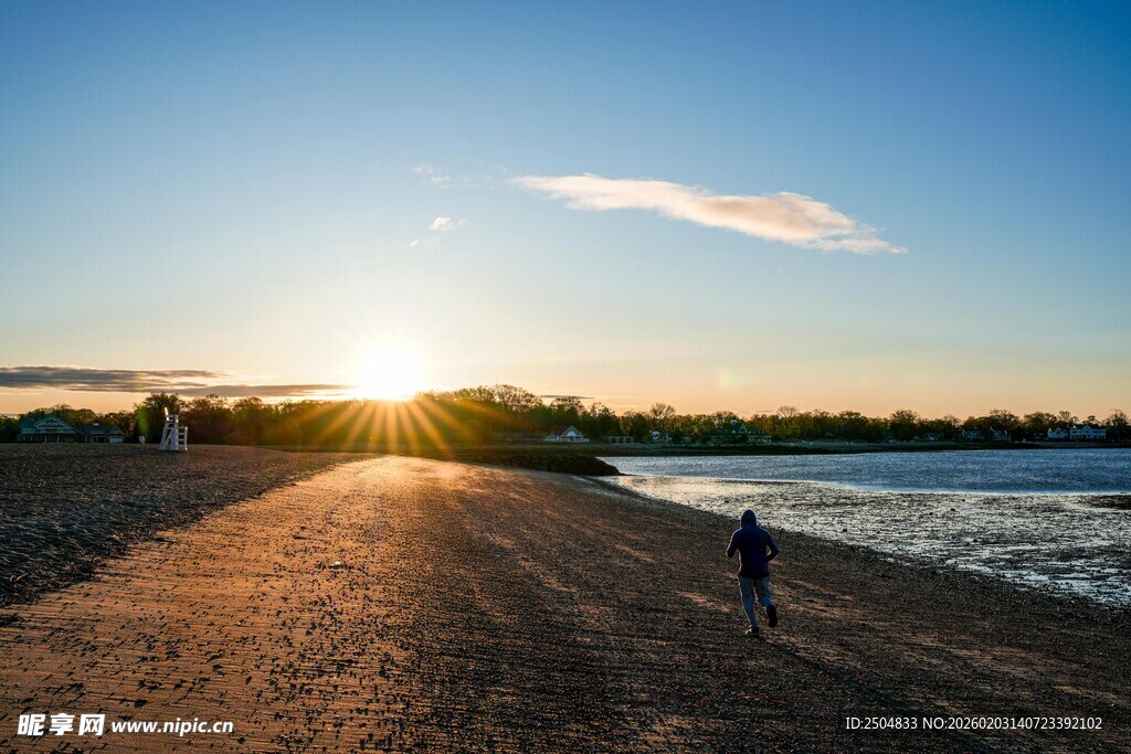 夕阳下的海边漫步身影