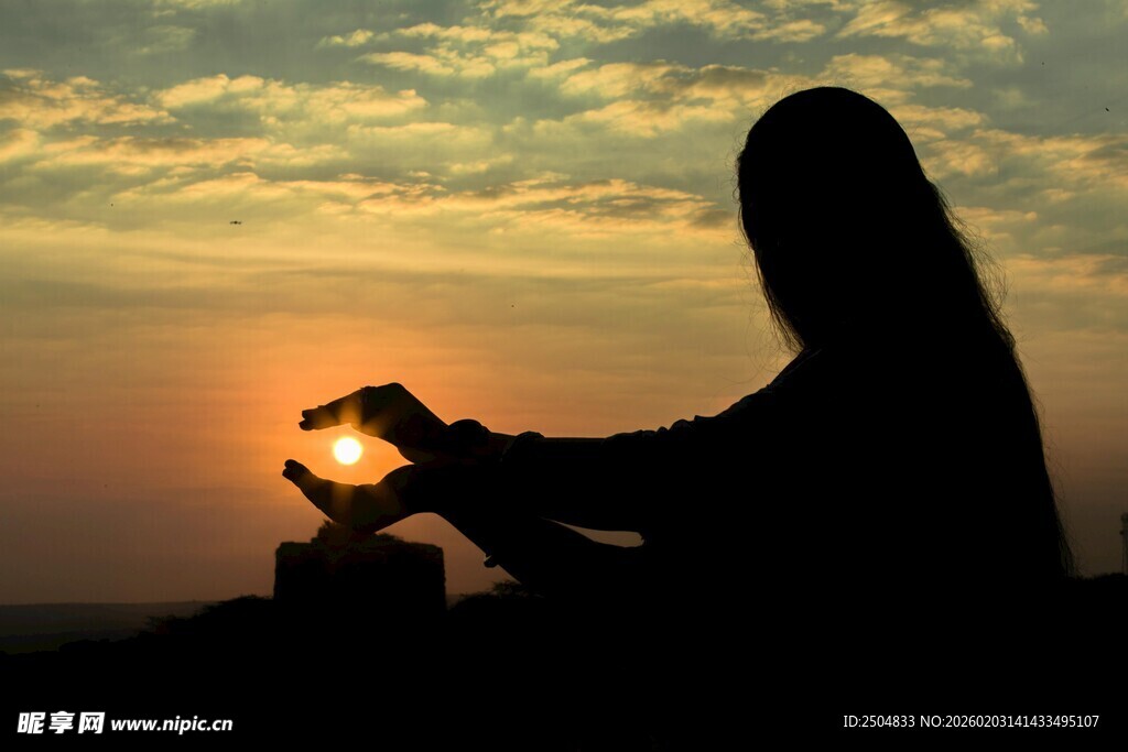 夕阳下的双手爱心剪影