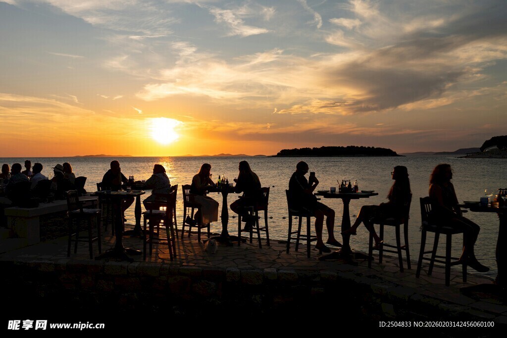 夕阳下海边的休闲人群