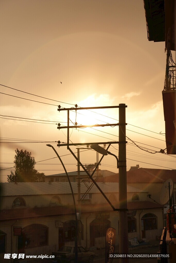 夕阳下的电线杆与城市景象