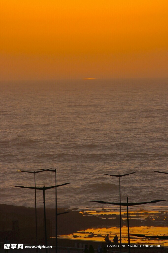 海边日落时的电力设施景观