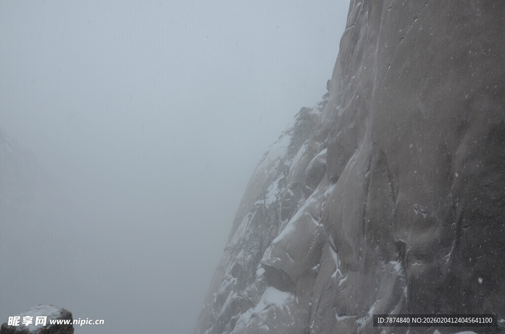 雾中覆雪的陡峭山壁