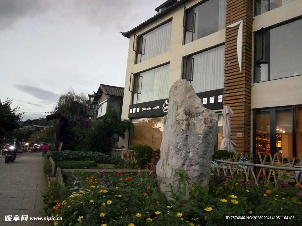 现代建筑旁的花草与石碑