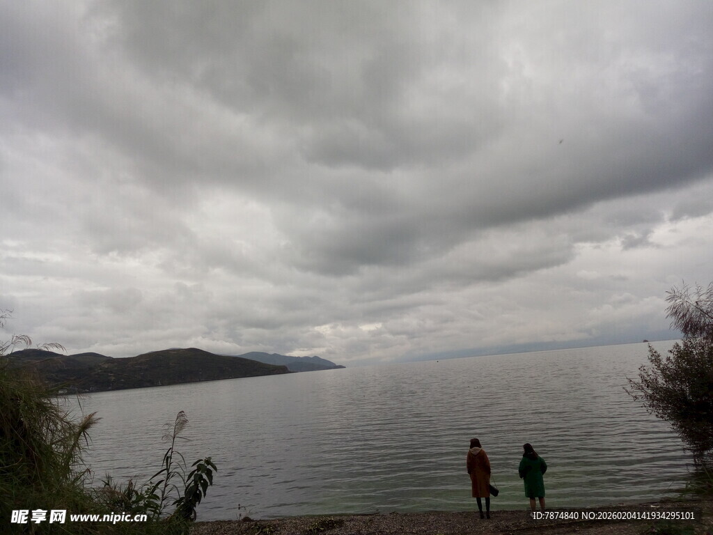 湖畔阴云下的两人漫步