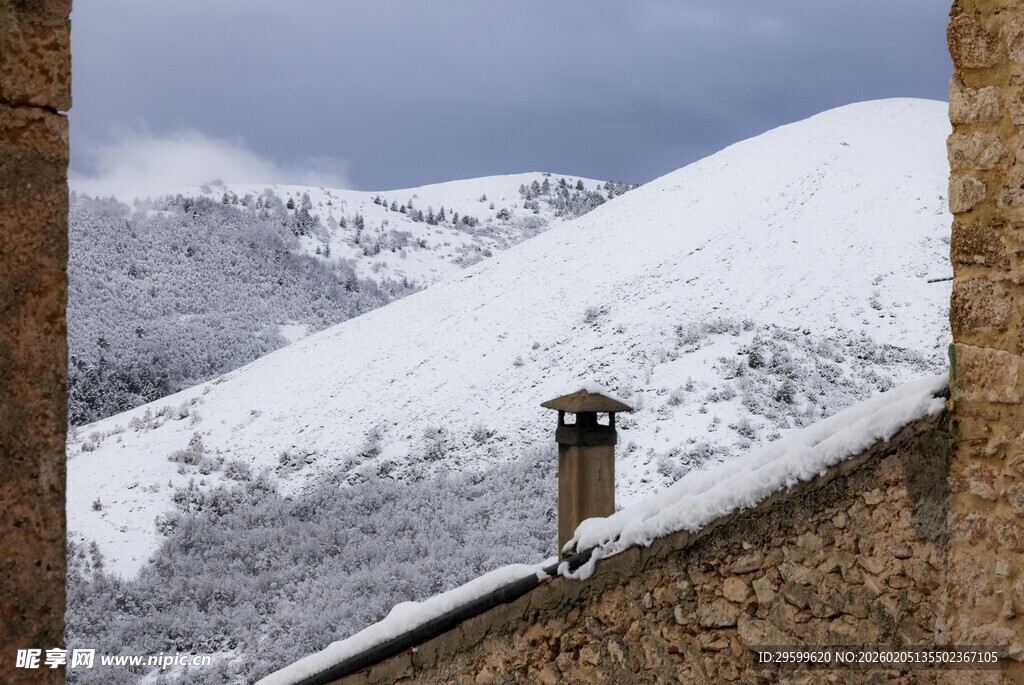 雪覆山峦下的古朴屋顶