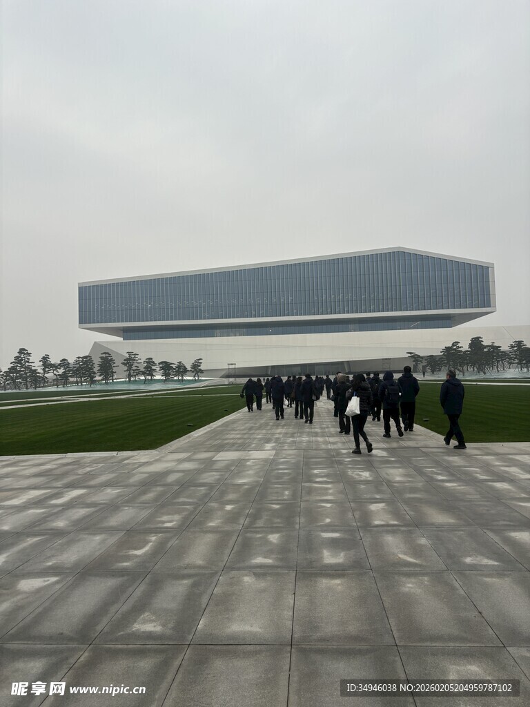 行人漫步于现代建筑前