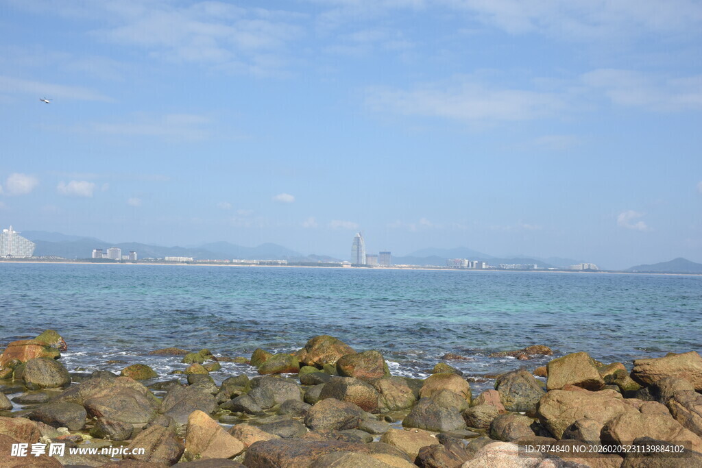 三亚海边礁石与远处城市风景