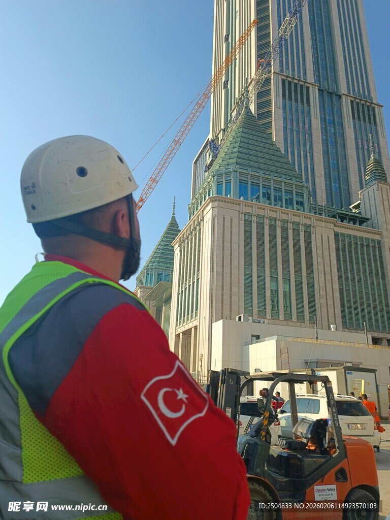 建筑工人仰视高楼施工