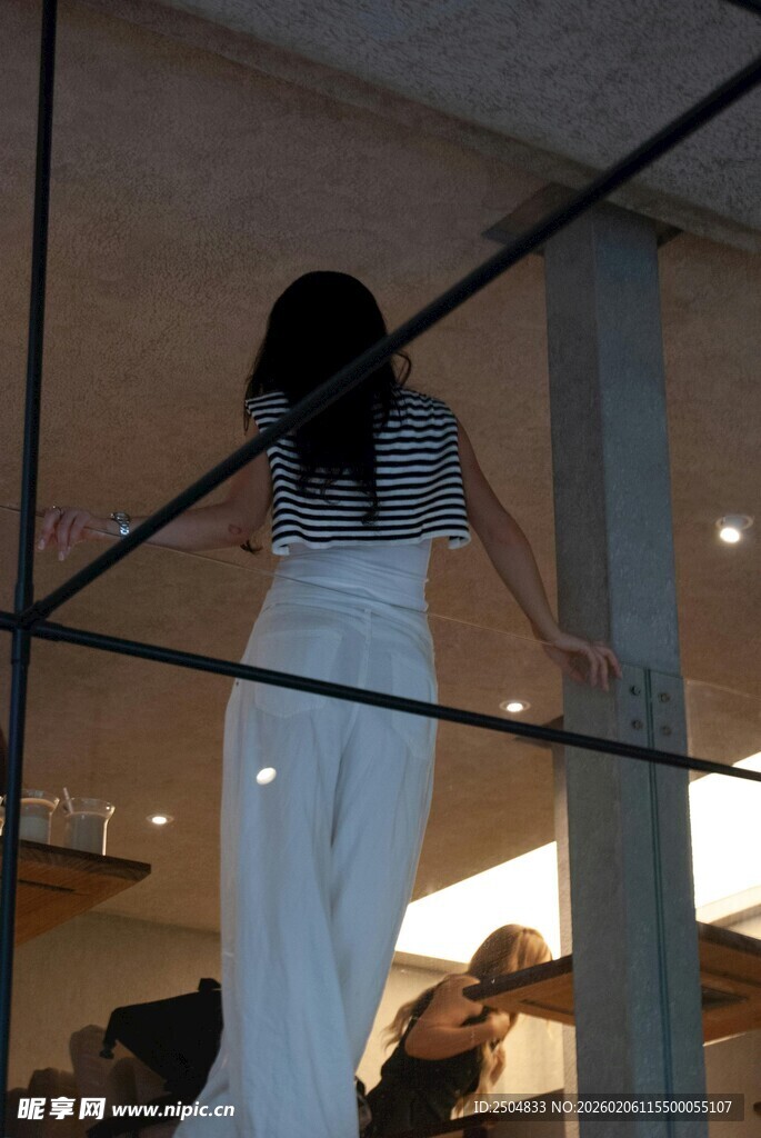 女子透过玻璃望向室内