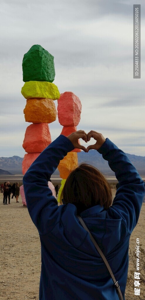 女子沙滩上对气球爱心比心