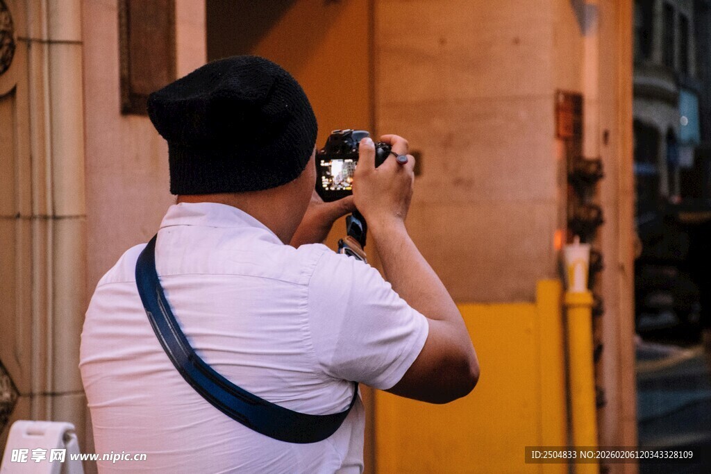男子街头专注拍照瞬间