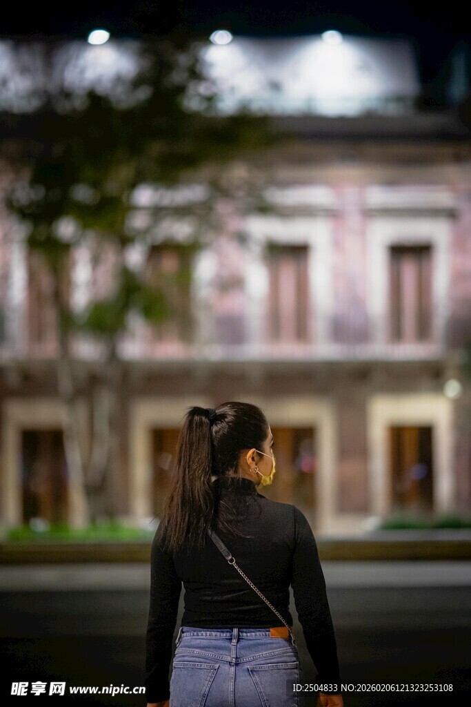 女子背身站立于复古建筑前