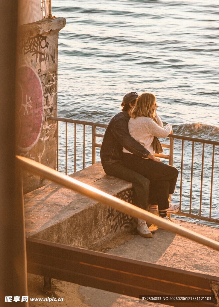 情侣海边石阶依偎赏景