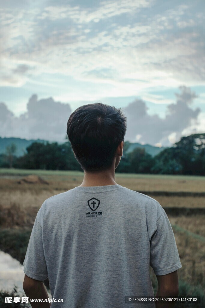 男子背对镜头望远方风景