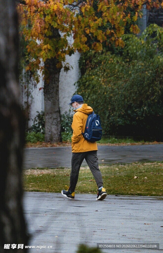 雨中漫步的背包行人